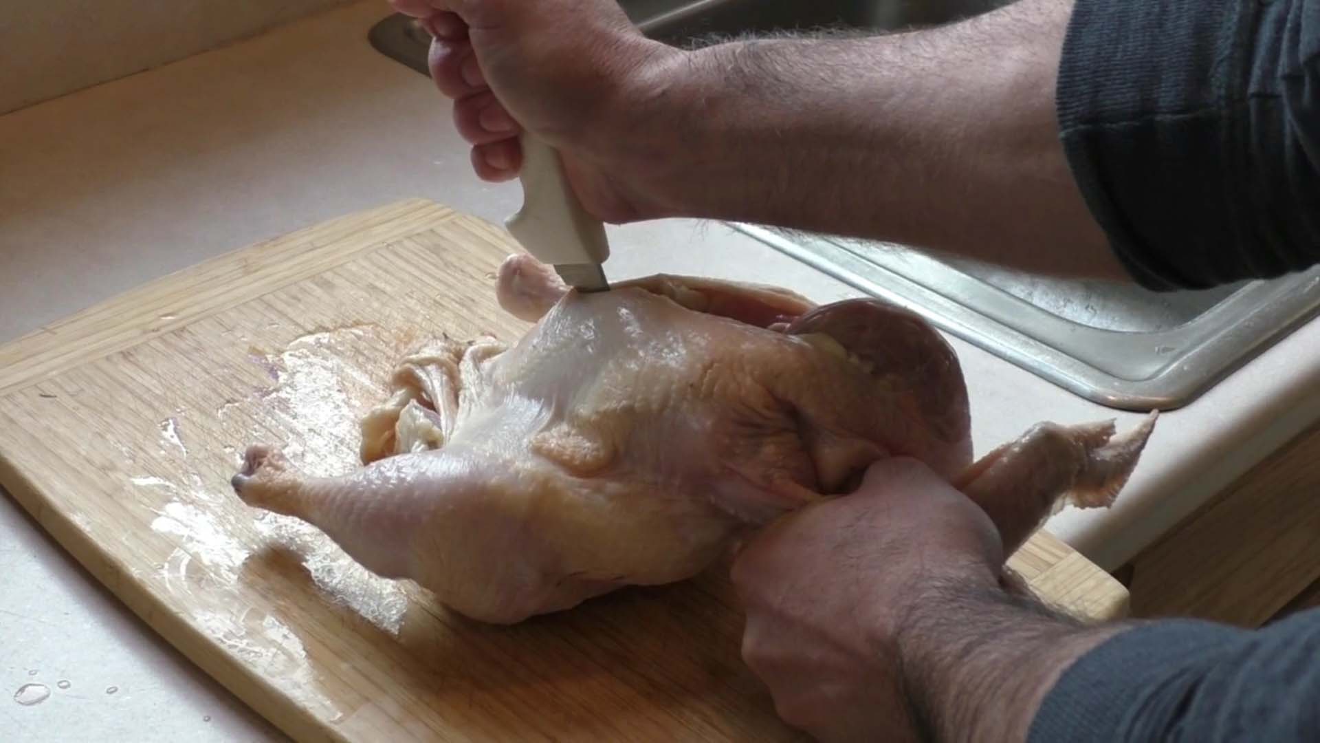 cutting a chicken with a knife